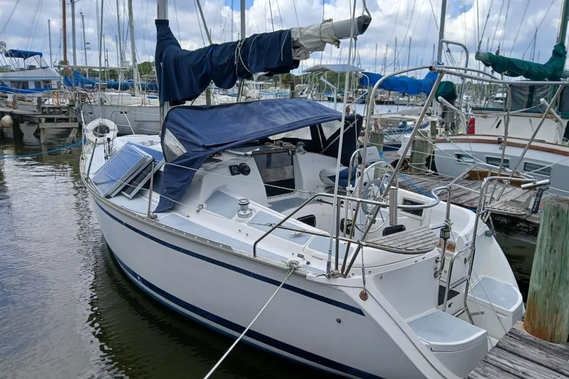 Slide: The Image of 1994 Hunter 30 sailboat docked at marina with blue canopy and solar panel. - 25