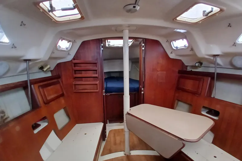 Slide: The Image of Interior of a 1994 Hunter 30 sailboat with wooden furnishings and seating area. - 3