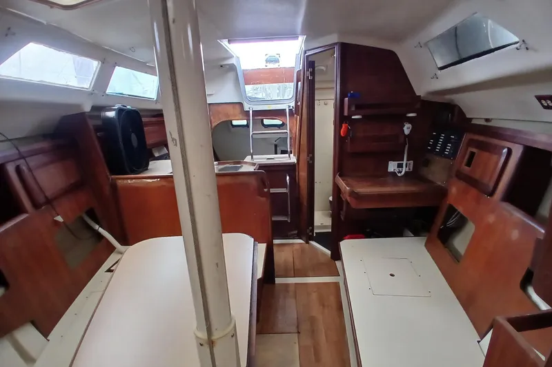Slide: The Image of Interior of a 1994 Hunter 30 sailboat, featuring wood finishes and compact design. - 4