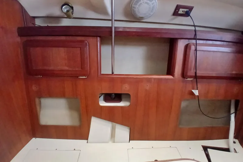 Slide: The Image of Interior of a 1994 Hunter 30 sailboat featuring wooden cabinetry and speaker. - 5