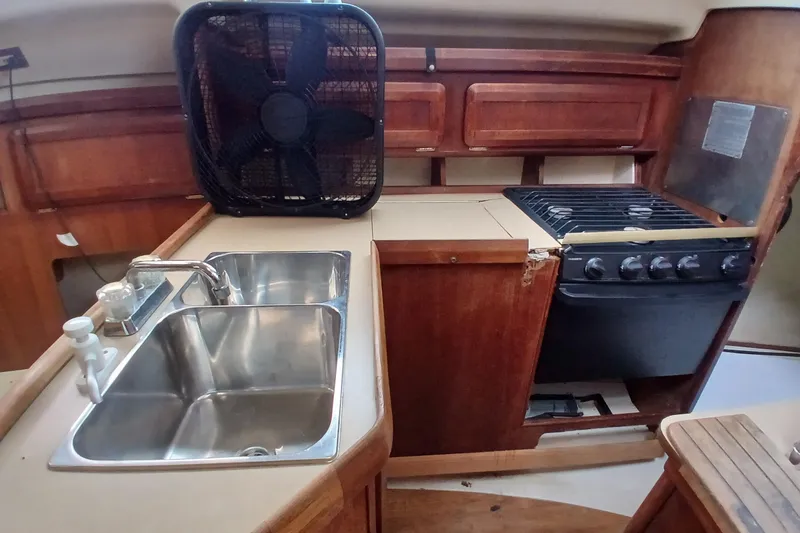 Slide: The Image of 1994 Hunter 30 yacht kitchen with sink, stove, and fan. - 7