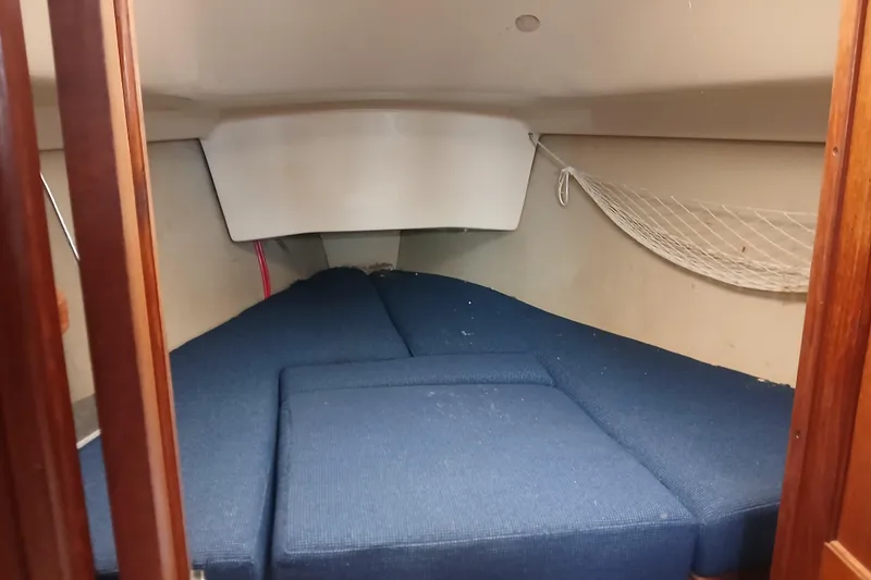 Slide: The Image of Interior cabin of a 1994 Hunter 30 sailboat with blue cushions and storage net. - 9