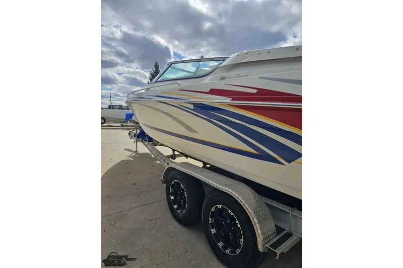 Slide: The Image of 2008 Formula 271 FASTech boat on trailer, featuring colorful graphics under a cloudy sky. - 23