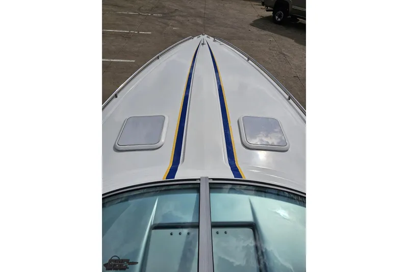 Slide: The Image of 2008 Formula 271 FASTech boat deck with blue and yellow stripes, docked on concrete. - 57