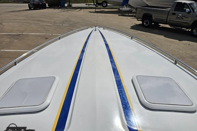 Slide: The Image of 2008 Formula 271 FASTech boat with blue and yellow stripes on deck, parked outdoors. - 59