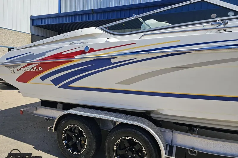 Slide: The Image of 2008 Formula 271 FASTech boat with colorful graphics on a trailer, parked outdoors. - 8