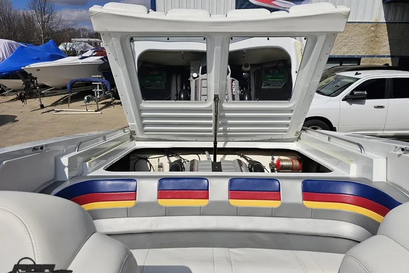 Slide: The Image of 2008 Formula 271 FASTech boat engine compartment with colorful seating, parked outdoors. - 82