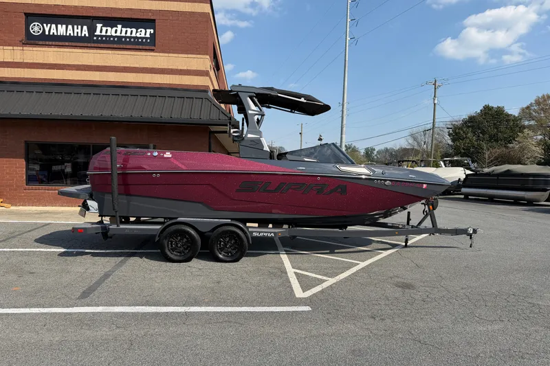 The Image of 2023 Supra SL 550 boat on trailer outside Yamaha Indmar building. - 1