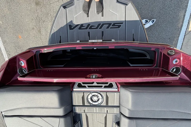 Slide: The Image of 2023 Supra SL 550 boat interior with maroon accents and storage compartment. - 14