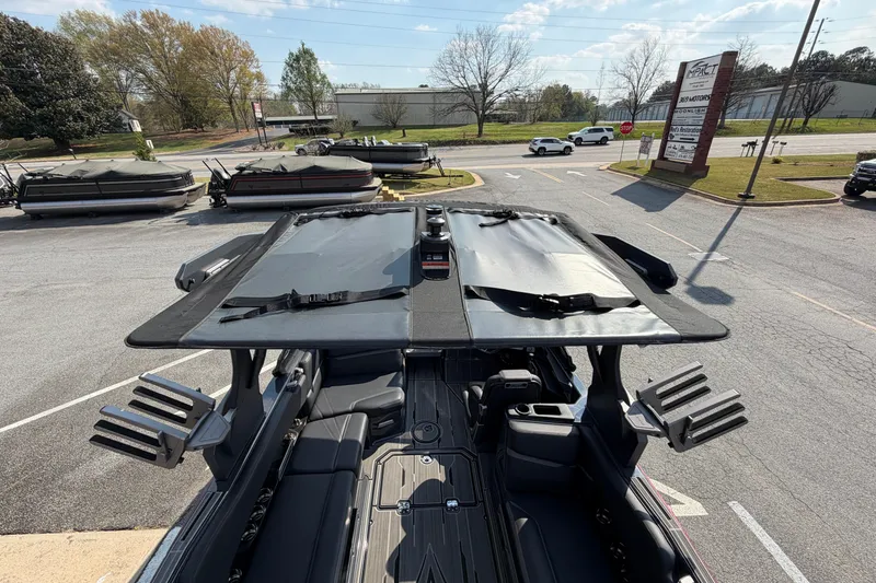 Slide: The Image of 2023 Supra SL 550 boat with open canopy, parked outdoors on a sunny day. - 16