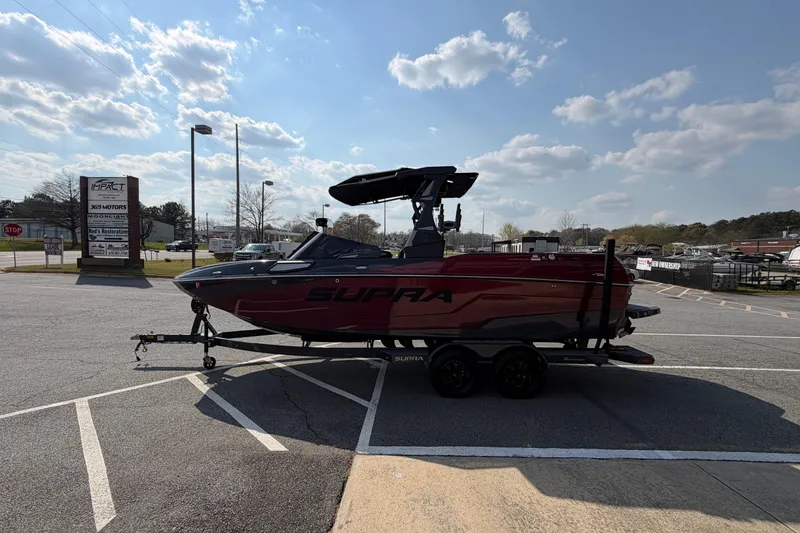 Slide: The Image of 2023 Supra SL 550 boat on trailer in parking lot under blue sky. - 7