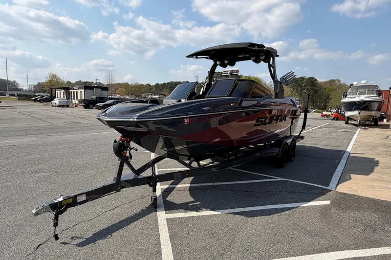 Slide: The Image of 2023 Supra SL 550 boat on trailer in parking lot under blue sky. - 8