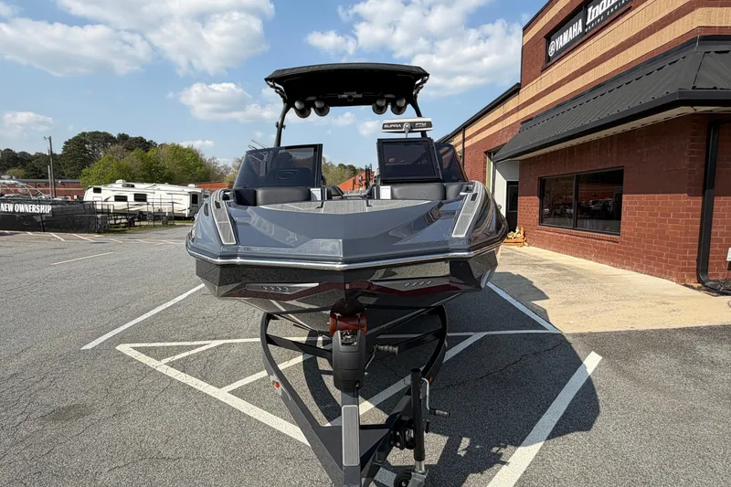 Slide: The Image of 2023 Supra SL 550 boat on trailer, parked outside dealership under blue sky. - 9