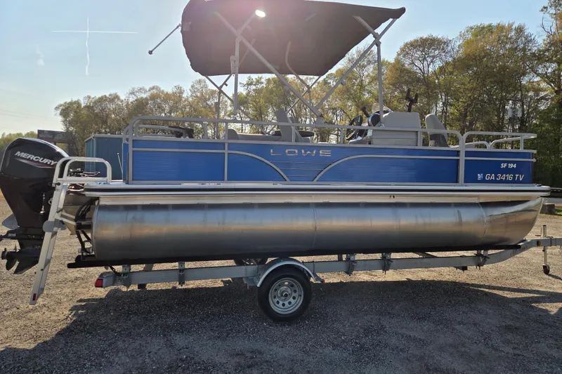 Slide: The Image of 2022 Lowe SF 194 Sport Fish pontoon boat on trailer, parked outdoors. - 4