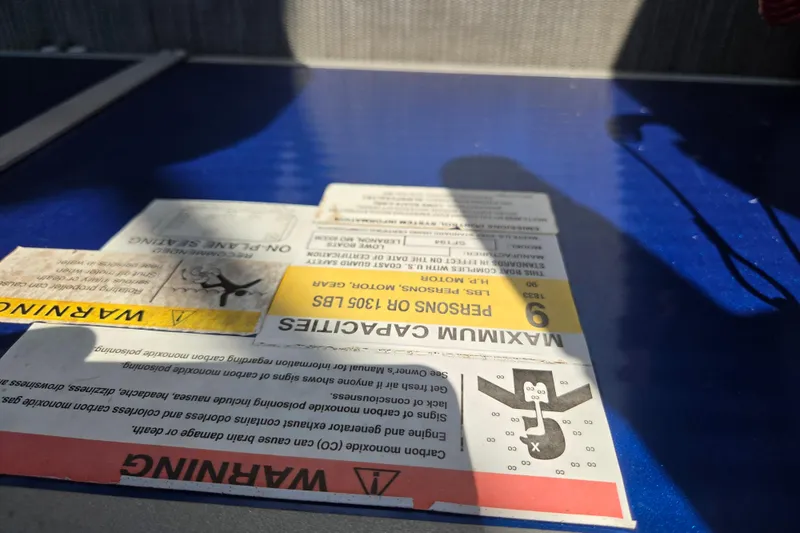 Slide: The Image of Warning labels on a 2022 Lowe SF 194 Sport Fish boat, highlighting safety and capacity information. - 7