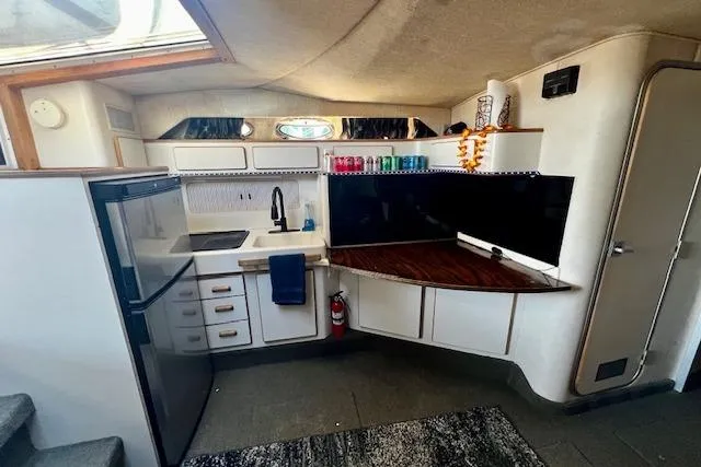 Slide: The Image of Interior of 1994 Sea Ray 400 Express Cruiser with kitchenette and modern amenities. - 35
