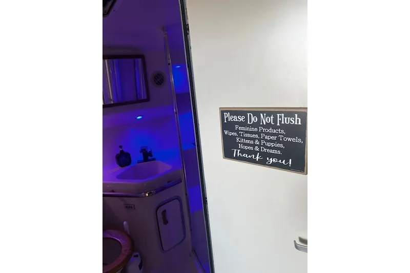 Slide: The Image of 1994 Sea Ray 400 Express Cruiser bathroom with humorous "Do Not Flush" sign. - 38