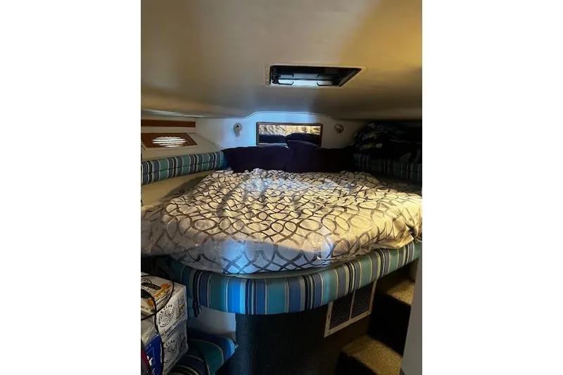 Slide: The Image of Cozy cabin interior of 1994 Sea Ray 400 Express Cruiser with patterned bedding. - 39