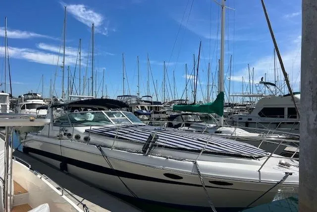 Slide: The Image of 1994 Sea Ray Sundancer 400 yacht docked in a marina under a clear blue sky. - 6