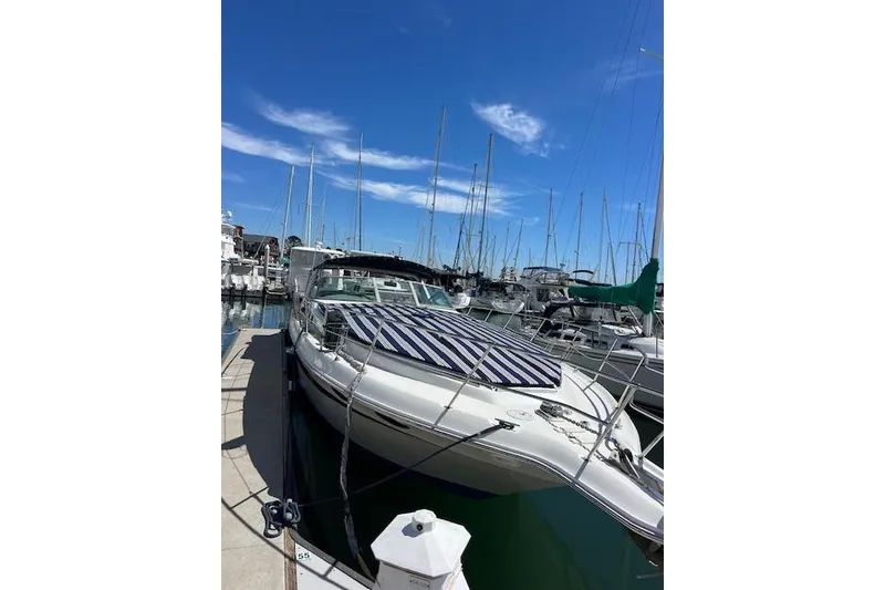 Slide: The Image of 1994 Sea Ray Sundancer 400 boat logo on white hull, docked at marina. - 8