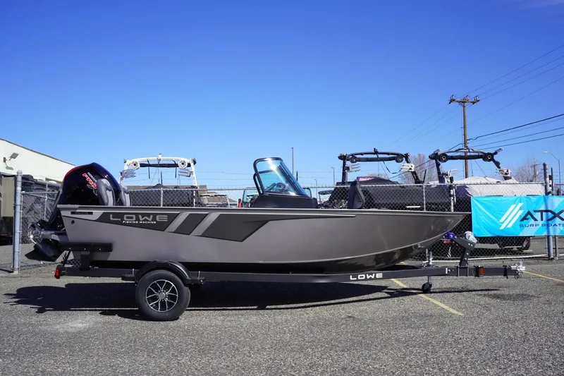 The Image of 2026 Lowe Fishing Machine 1775WT boat on trailer in outdoor lot. - 1