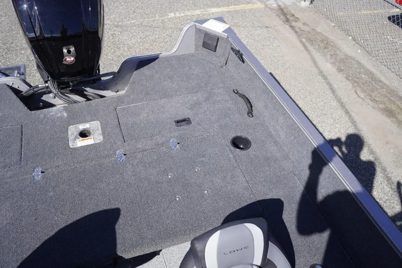 Slide: The Image of 2026 Lowe Fishing Machine 1775WT boat interior with carpeted deck and seating. - 23