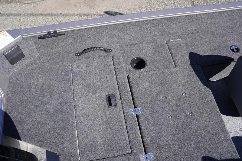 Slide: The Image of 2026 Lowe Fishing Machine 1775WT boat deck with storage compartments and carpeted surface. - 27