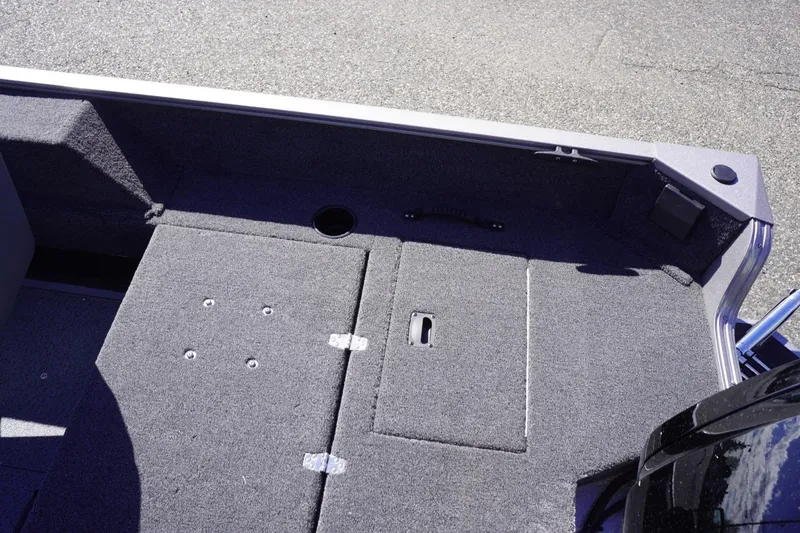 Slide: The Image of Interior view of 2026 Lowe Fishing Machine 1775WT boat, featuring carpeted storage compartments. - 28