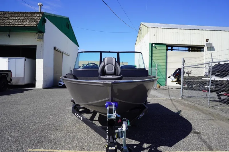 Slide: The Image of 2026 Lowe Fishing Machine 1775WT boat parked outside industrial buildings. - 3