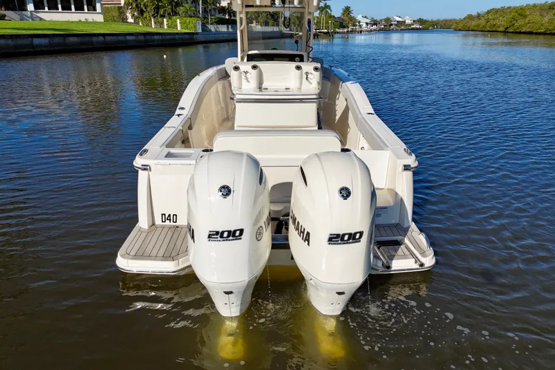 Slide: The Image of 2022 Scout 277 LXF boat with twin Yamaha 200 engines on a calm waterway. - 10