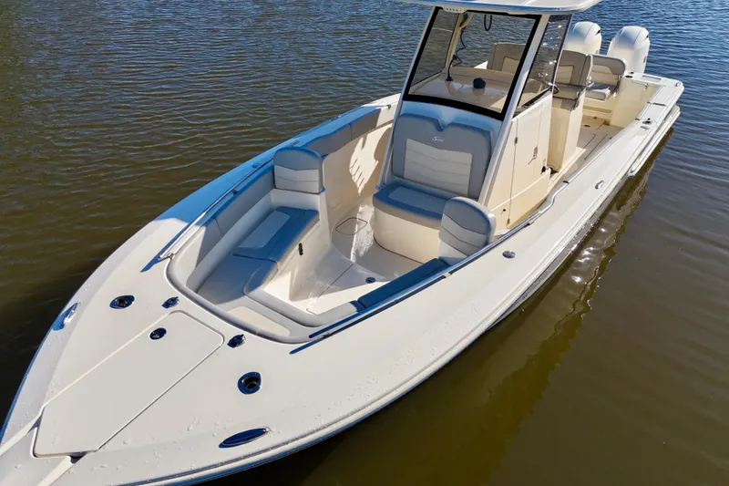 Slide: The Image of 2022 Scout 277 LXF boat on calm water, showcasing sleek design and spacious seating. - 13