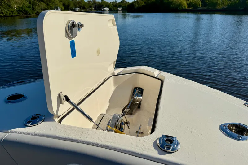 Slide: The Image of 2022 Scout 277 LXF boat anchor compartment open on calm water. - 16