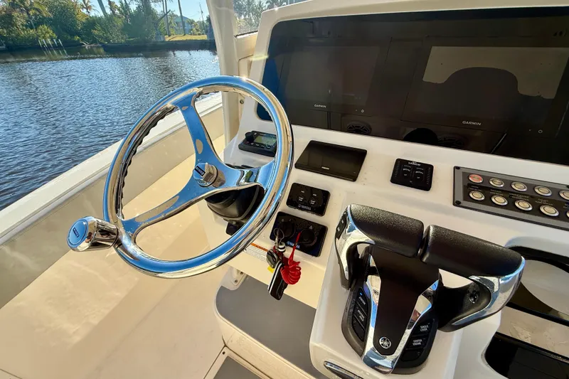 Slide: The Image of 2022 Scout 277 LXF boat helm with steering wheel and control panel. - 21