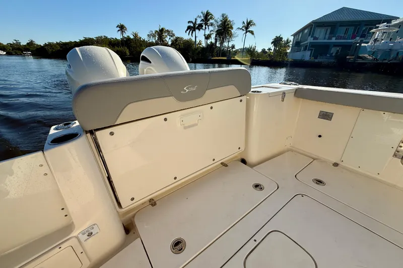 Slide: The Image of 2022 Scout 277 LXF boat interior with seating, on a sunny waterfront. - 31
