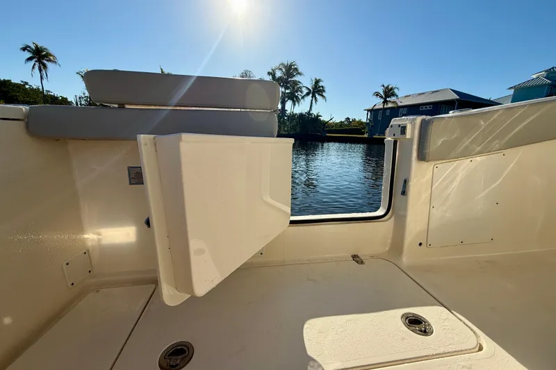 Slide: The Image of 2022 Scout 277 LXF boat interior with open hatch, sunny waterfront view. - 32