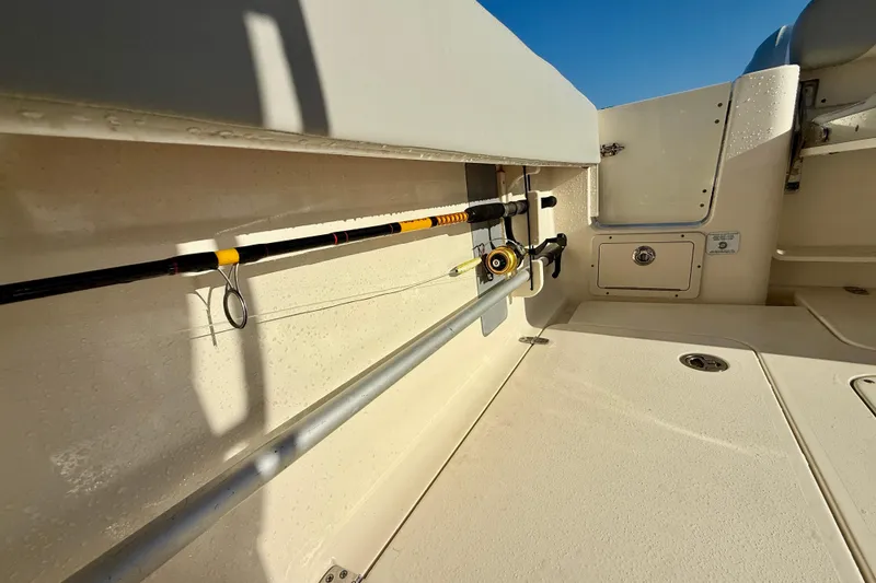 Slide: The Image of 2022 Scout 277 LXF boat interior with fishing rod holder and storage compartments. - 34