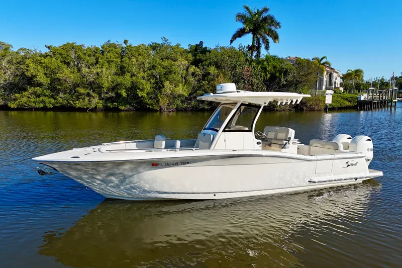 Slide: The Image of 2022 Scout 277 LXF boat on a calm river with lush greenery background. - 4