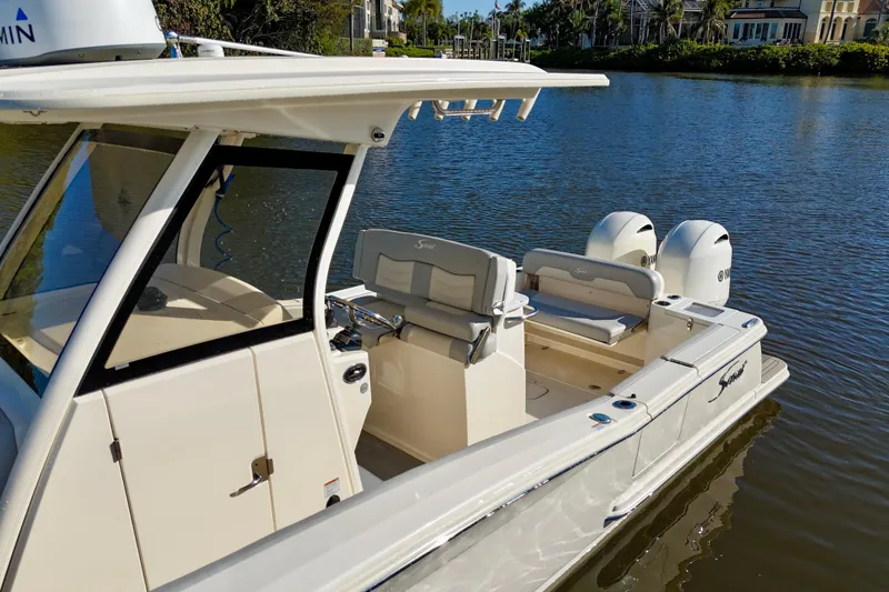 Slide: The Image of 2022 Scout 277 LXF boat with dual engines on a calm waterway. - 7