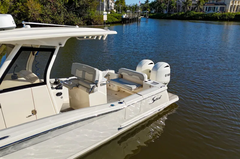 Slide: The Image of 2022 Scout 277 LXF boat on calm water, featuring dual Yamaha engines. - 8