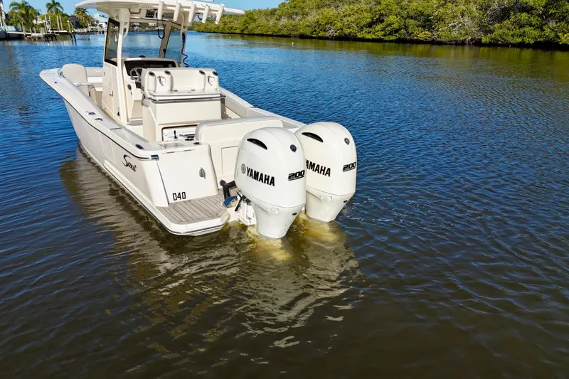 Slide: The Image of 2022 Scout 277 LXF boat with twin Yamaha engines on calm water. - 9