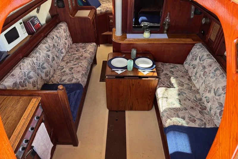 Slide: The Image of Interior of a 1977 Islander 32 sailboat with floral upholstery and wooden finishes. - 15