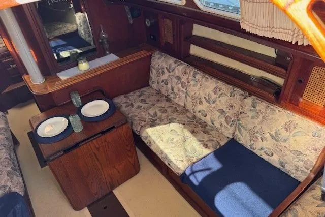 Slide: The Image of 1977 Islander 32 sailboat interior with floral upholstery and dining setup. - 16