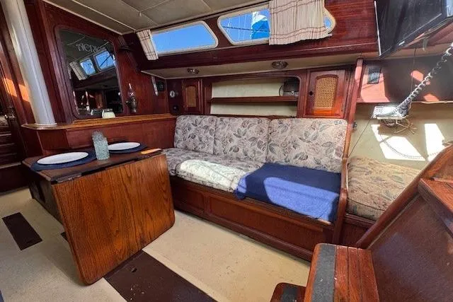 Slide: The Image of 1977 Islander 32 sailboat interior with wood finish, floral upholstery, and dining area. - 18