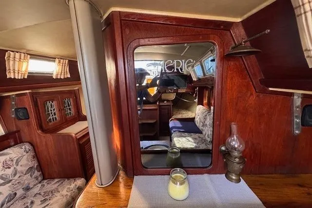 Slide: The Image of 1977 Islander 32 yacht interior with wood paneling and cozy seating area. - 21