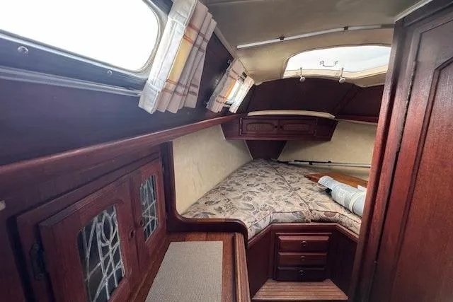 Slide: The Image of 1977 Islander 32 sailboat cabin with wood interior and cozy sleeping area. - 22