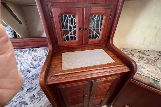 Slide: The Image of 1977 Islander 32 interior with wooden cabinetry and floral upholstery. - 23