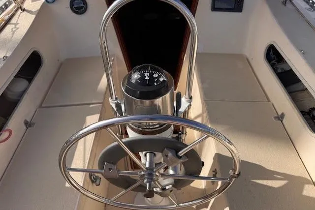 Slide: The Image of 1977 Islander 32 sailboat cockpit with steering wheel and compass. - 4