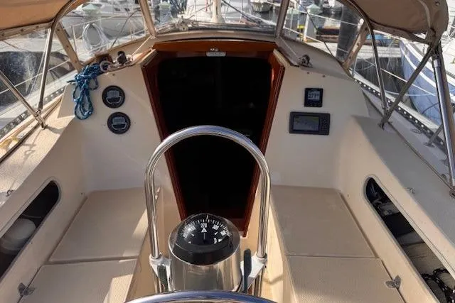 Slide: The Image of 1977 Islander 32 sailboat cockpit with steering wheel, compass, and navigation instruments. - 5