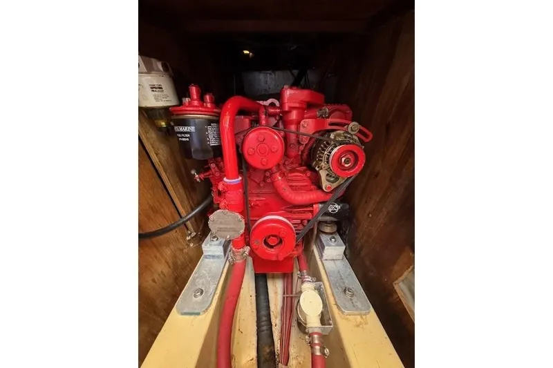 Slide: The Image of Red engine inside a 1977 Islander 32 sailboat, showcasing mechanical components. - 6