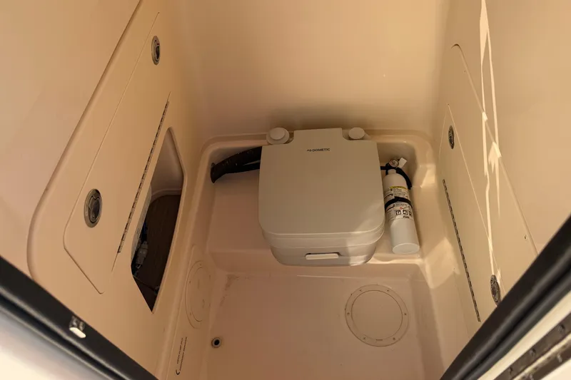 Slide: The Image of 2024 Grady-White Fisherman 236 boat interior with portable toilet and fire extinguisher. - 26